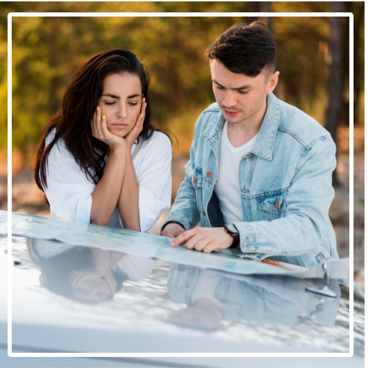 Couple studying map on car hood